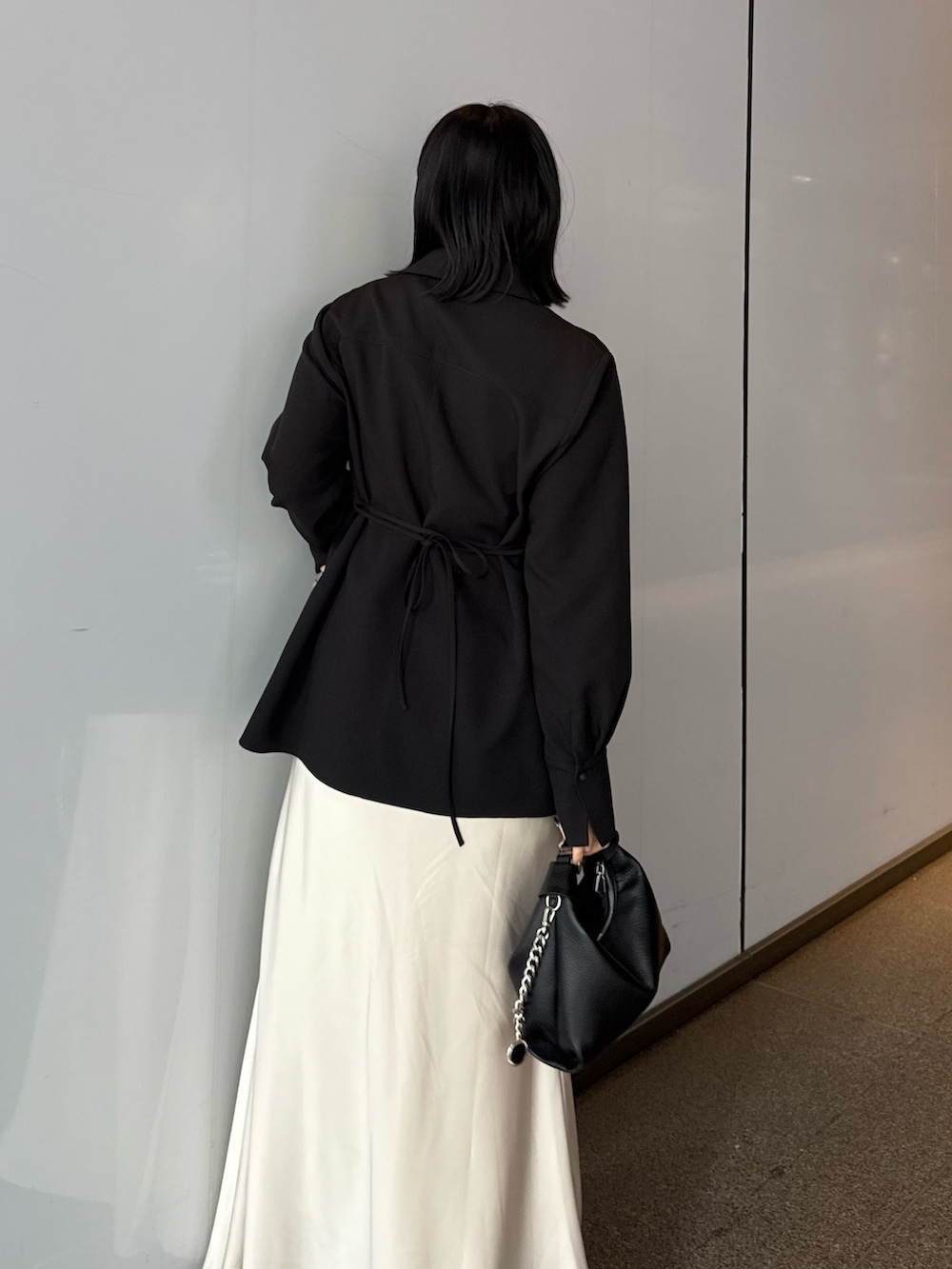 ブラック系のシャツ/ブラウス、ホワイト系のスカート、ブラック系のトートバッグを着用したレディースの春コーディネートの4枚目の写真