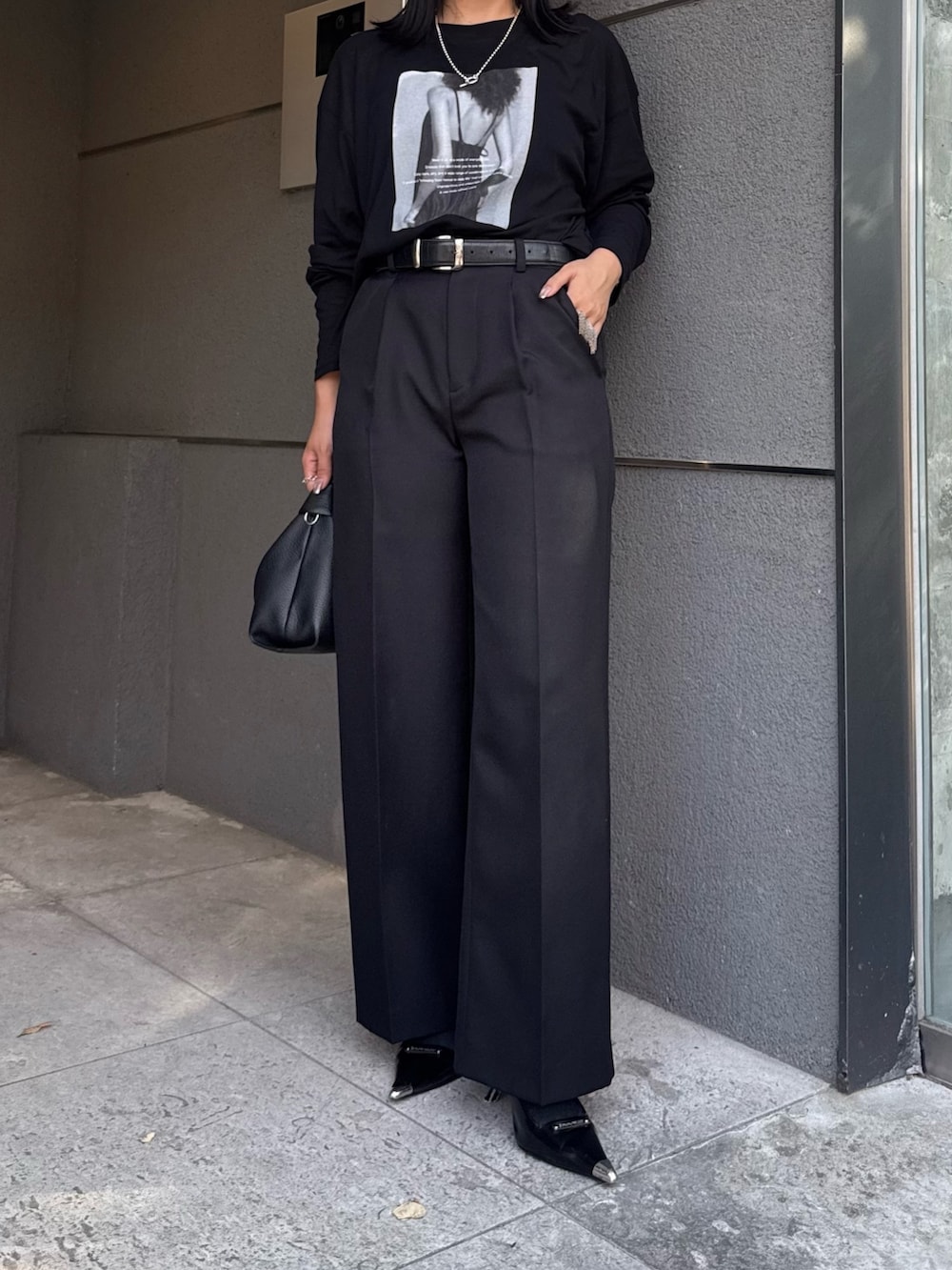 ブラック系のTシャツ/カットソー、ブラック系のスラックス、ブラック系のショルダーバッグを着用したレディースの夏コーディネートの5枚目の写真