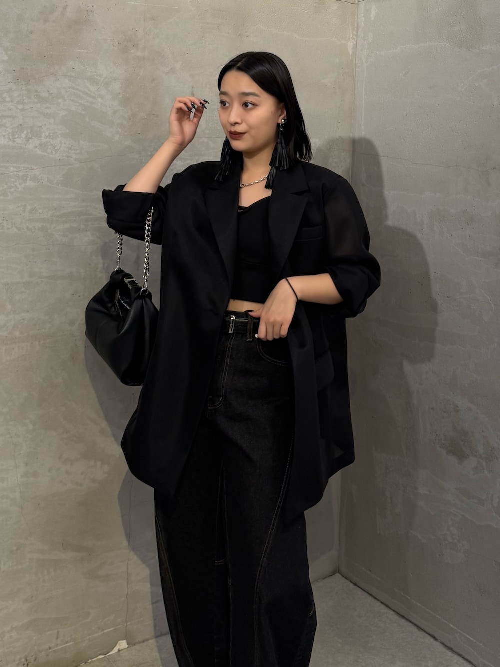 ブラック系のテーラードジャケット、ブラック系のデニムパンツ、ブラック系のトートバッグを着用したレディースの冬コーディネートの4枚目の写真