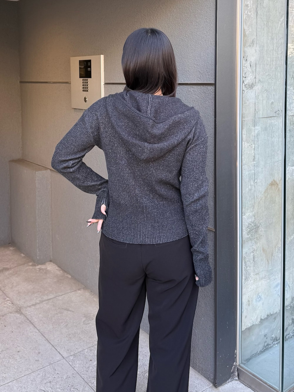 ブラック系のニット/セーター、ブラック系のスラックス、ブラック系のベルトを着用したレディースの冬コーディネートの4枚目の写真