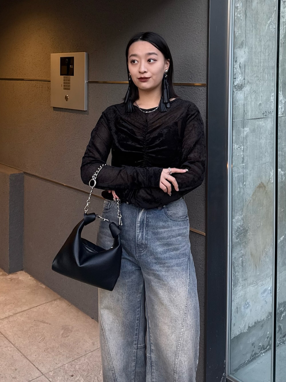 ブラック系のTシャツ/カットソー、ブルー系のデニムパンツ、ブラック系のトートバッグを着用したレディースの冬コーディネートの3枚目の写真