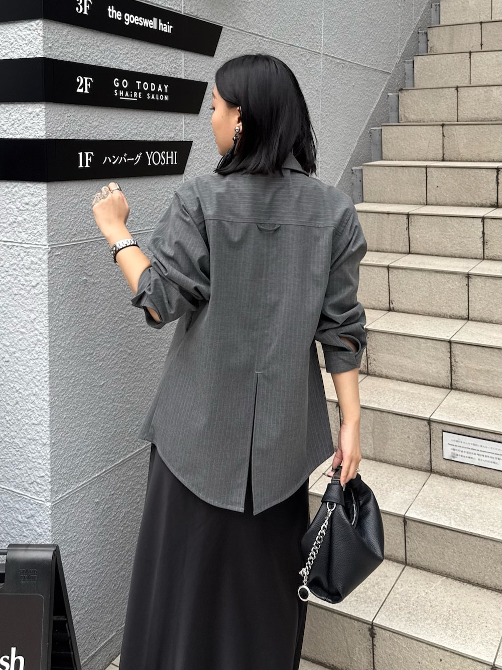 グレー系のシャツ/ブラウス、ブラック系のスカート、ブラック系のトートバッグを着用したレディースの春コーディネートの4枚目の写真