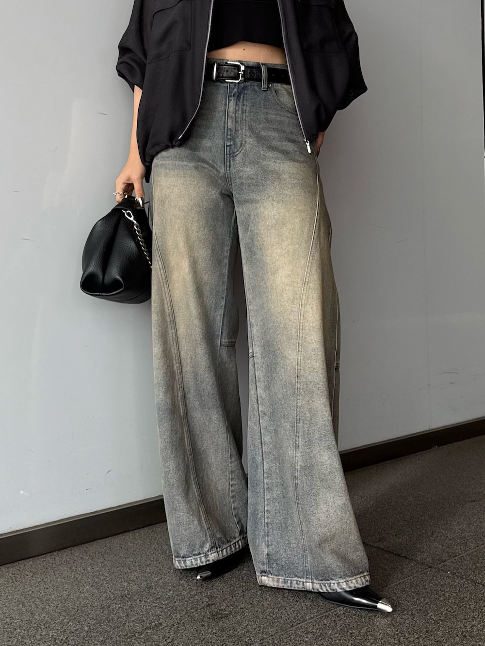 グレー系のブルゾン、ブルー系のデニムパンツ、ブラック系のトートバッグを着用したレディースの春コーディネートの5枚目の写真