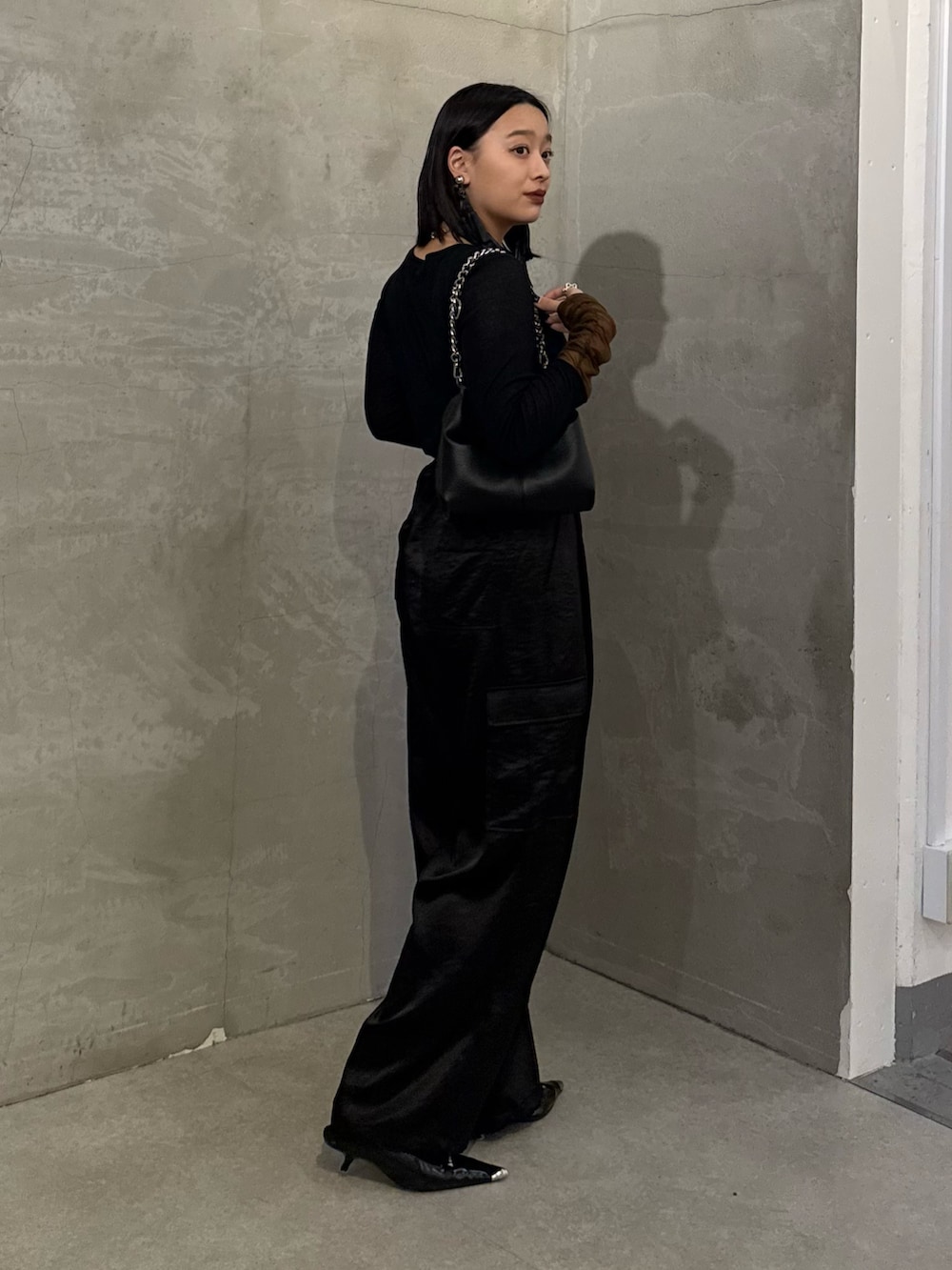 ブラック系のTシャツ/カットソー、ブラック系のカーゴパンツ、ブラック系のトートバッグを着用したレディースの冬コーディネートの2枚目の写真