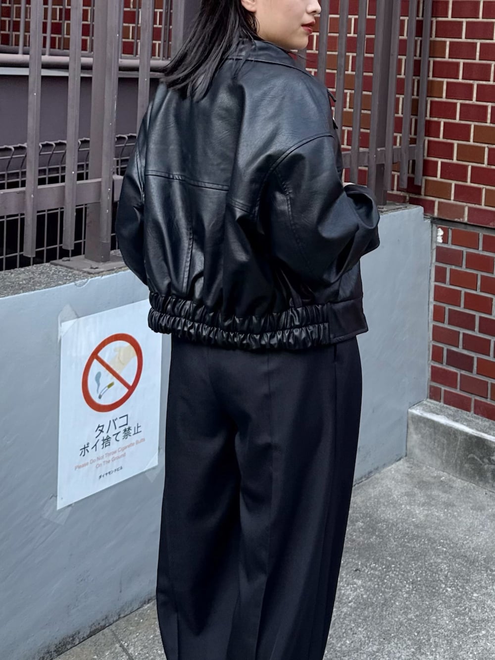 ブラック系のブルゾン、ベージュ系のニット/セーター、ブラック系のスラックスを着用したレディースの秋コーディネートの5枚目の写真