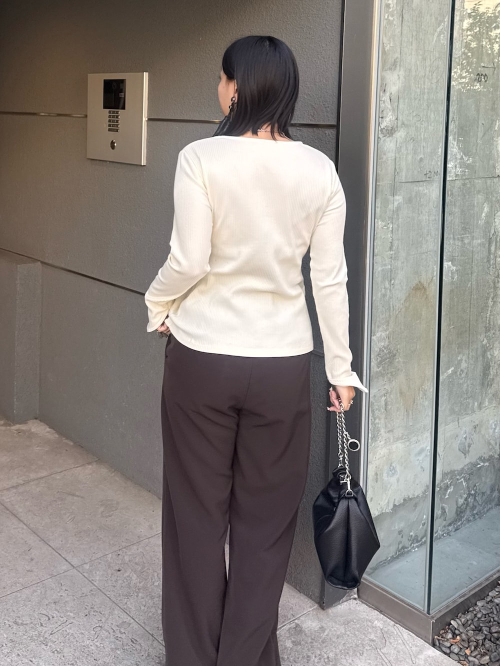 ホワイト系のTシャツ/カットソー、ブラウン系のスラックス、ブラック系のトートバッグを着用したレディースの冬コーディネートの4枚目の写真