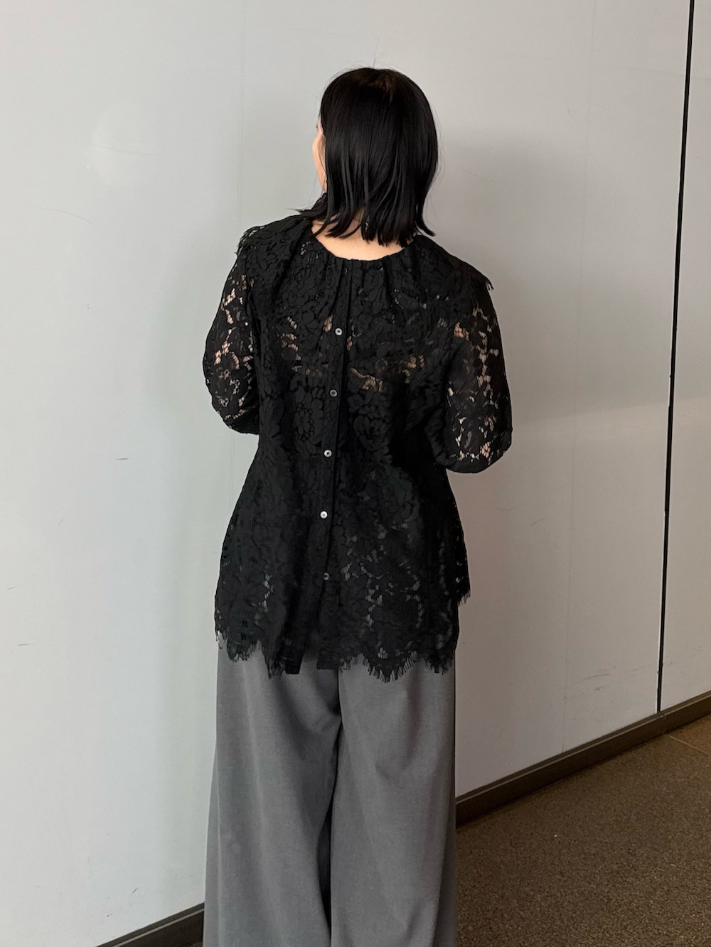 ブラック系のシャツ/ブラウス、グレー系のスラックス、ブラック系のトートバッグを着用したレディースの春コーディネートの4枚目の写真