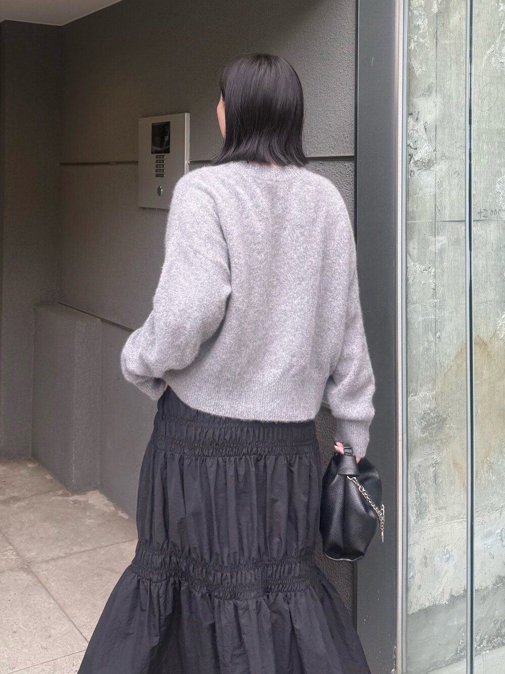 グレー系のカーディガン/ボレロ、ブラック系のスカート、ブラック系のトートバッグを着用したレディースの夏コーディネートの4枚目の写真
