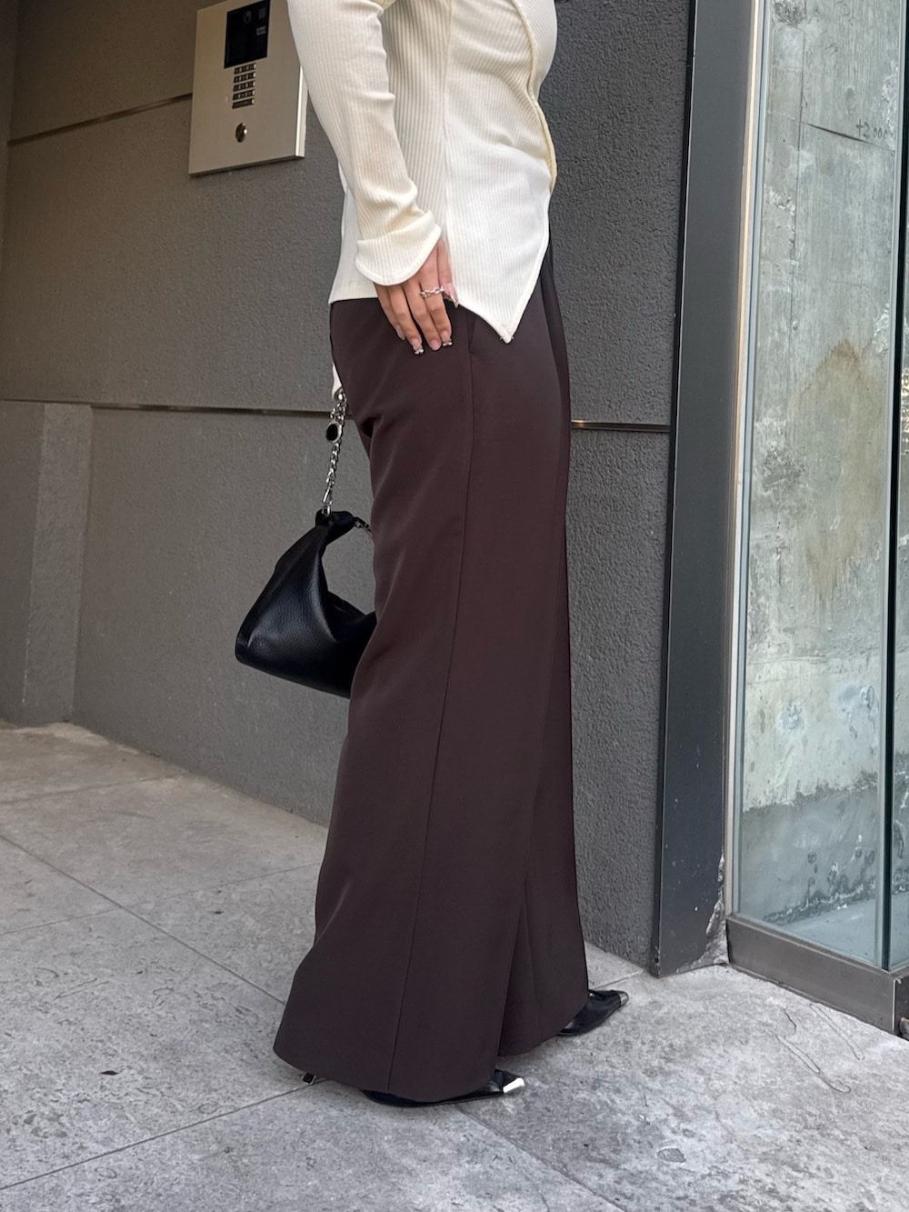 ホワイト系のTシャツ/カットソー、ブラウン系のスラックス、ブラック系のトートバッグを着用したレディースの冬コーディネートの6枚目の写真