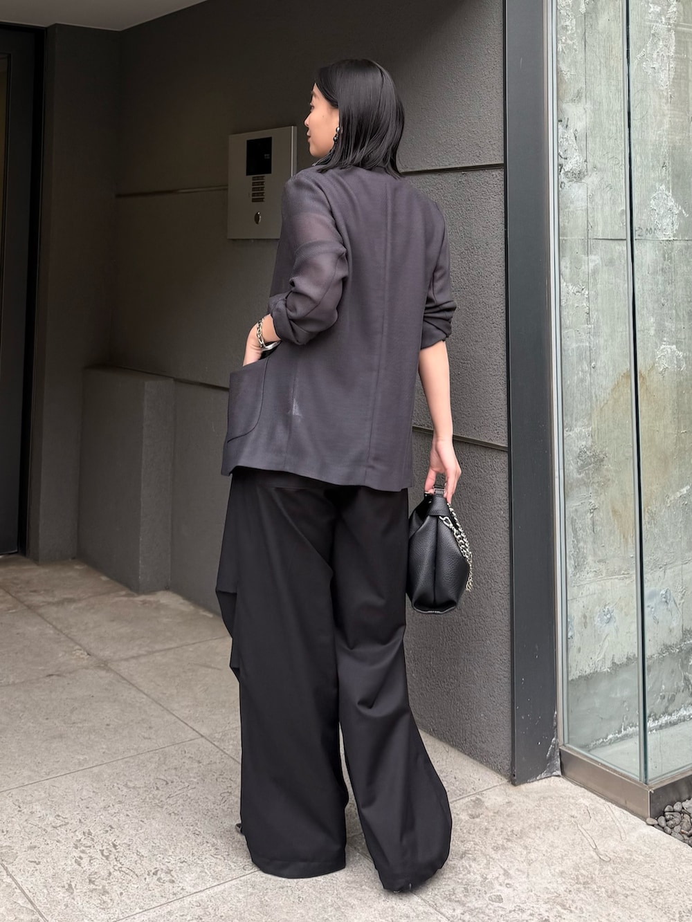グレー系のテーラードジャケット、ブラック系のカーゴパンツ、ブラック系のトートバッグを着用したレディースの春コーディネートの2枚目の写真