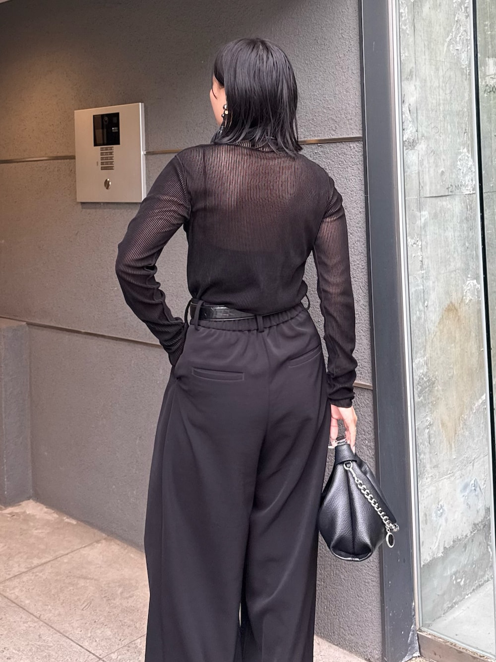 ブラック系のTシャツ/カットソー、ブラック系のスラックス、ブラック系のトートバッグを着用したレディースの秋コーディネートの4枚目の写真