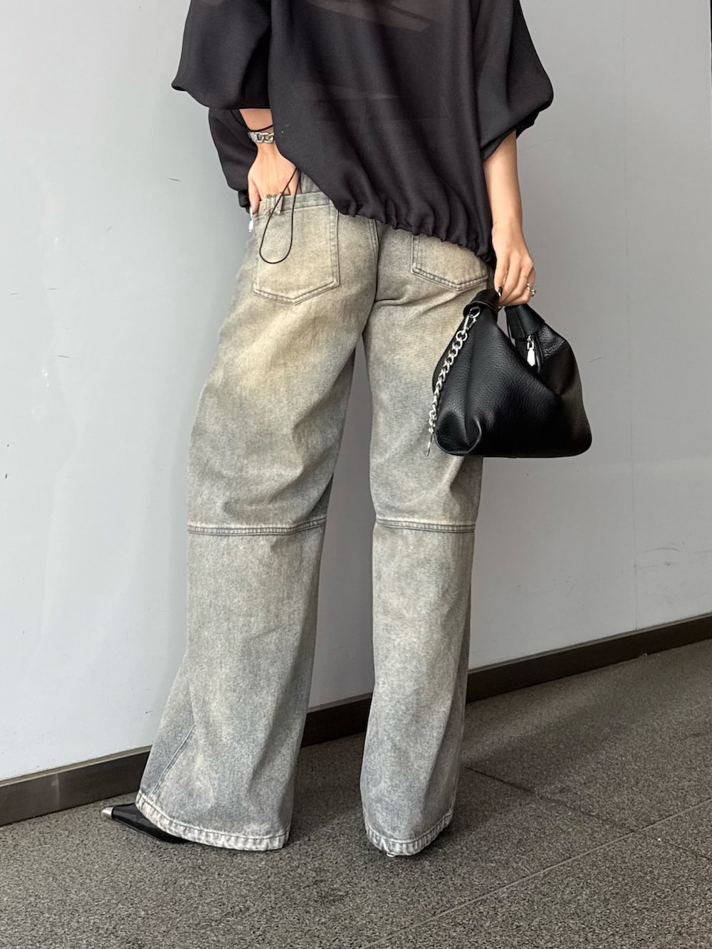 グレー系のブルゾン、ブルー系のデニムパンツ、ブラック系のトートバッグを着用したレディースの春コーディネートの6枚目の写真