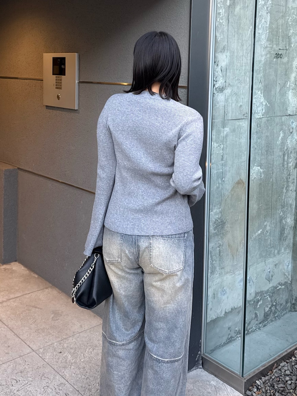 グレー系のニット/セーター、ブルー系のデニムパンツ、ブラック系のトートバッグを着用したレディースの冬コーディネートの4枚目の写真