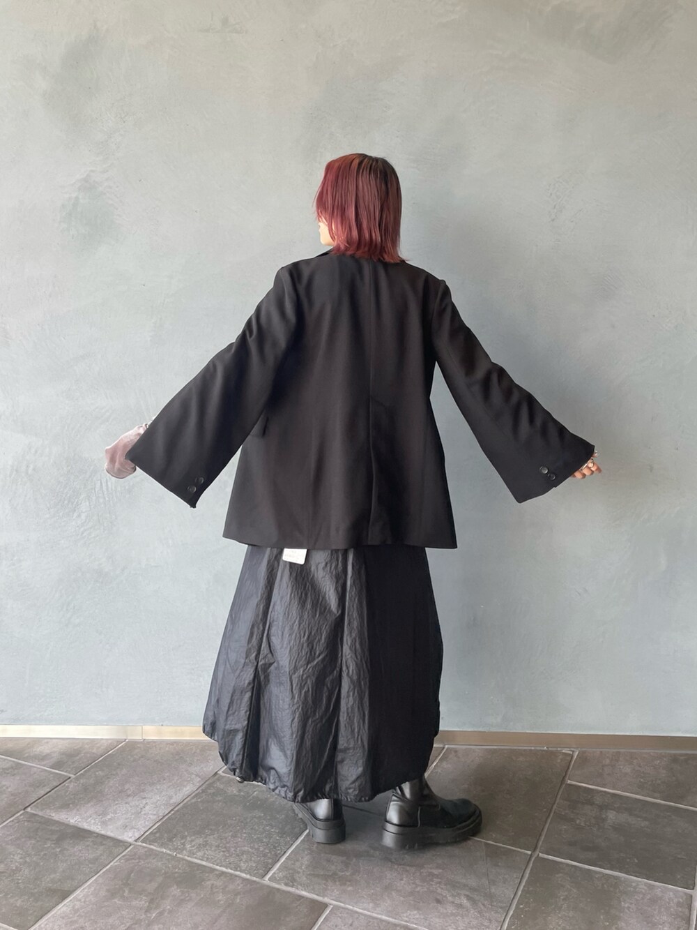 グリーン系のテーラードジャケット、ベージュ系のTシャツ/カットソー、ブラック系のスカートを着用したレディースの秋コーディネートの3枚目の写真