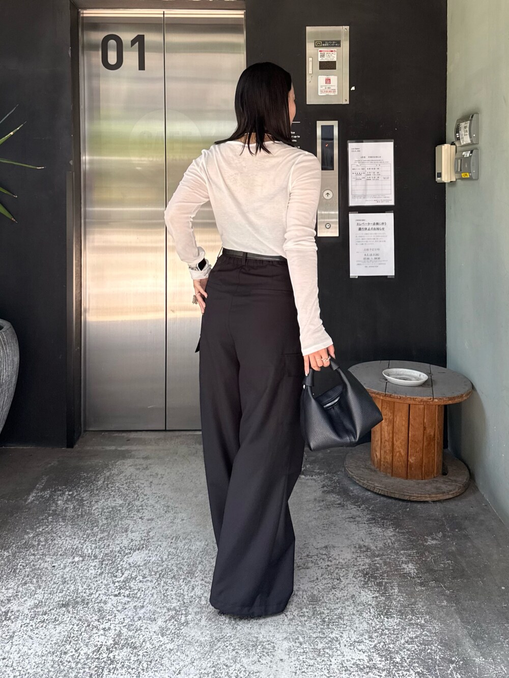 ホワイト系のTシャツ/カットソー、ブラック系のカーゴパンツ、ブラック系のショルダーバッグを着用したレディースの夏コーディネートの2枚目の写真