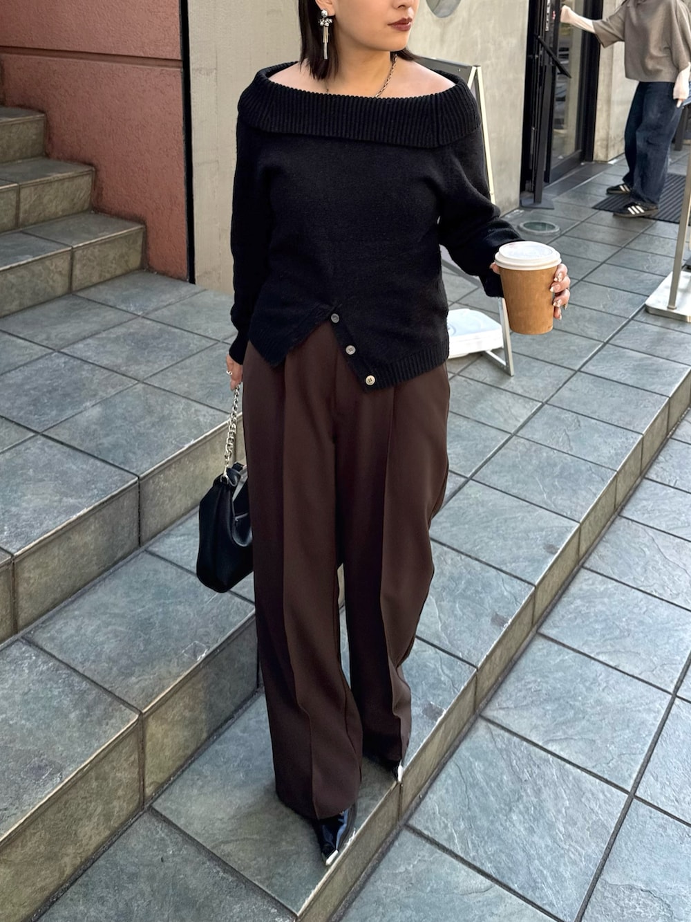 ブラック系のニット/セーター、ブラウン系のスラックス、ブラック系のトートバッグを着用したレディースの冬コーディネートの2枚目の写真