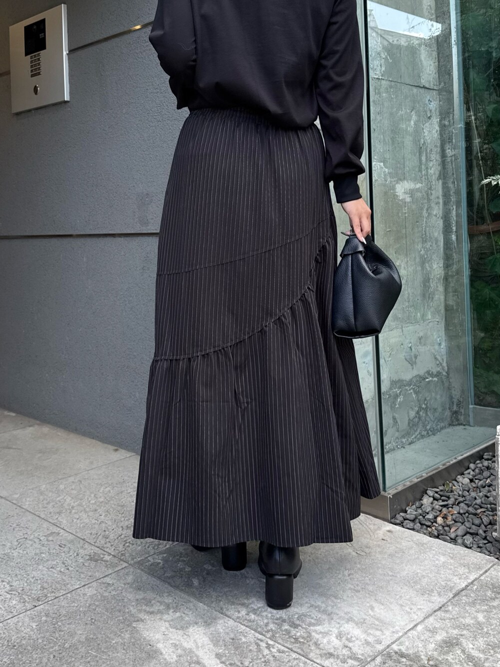 ブラック系のTシャツ/カットソー、ブラック系のスカート、ブラック系のトートバッグを着用したレディースの秋コーディネートの7枚目の写真