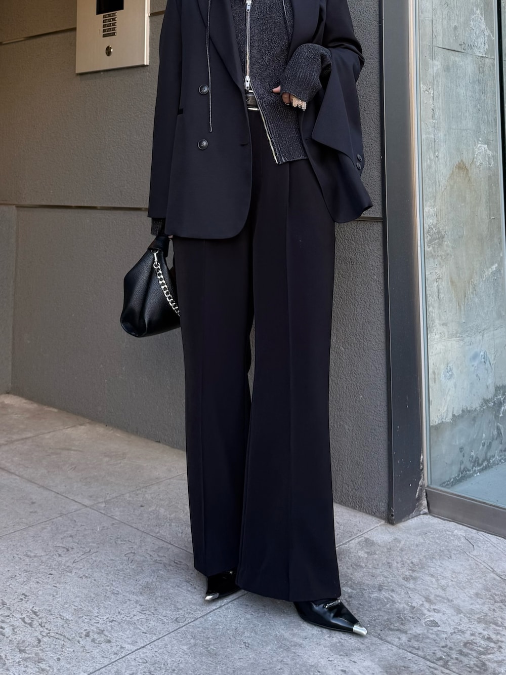 ブラック系のテーラードジャケット、ブラック系のニット/セーター、ブラック系のトートバッグを着用したレディースの冬コーディネートの6枚目の写真