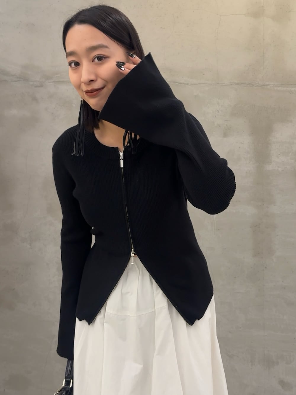 ブラック系のニット/セーター、ブラック系のショルダーバッグを着用したレディースの冬コーディネートの3枚目の写真