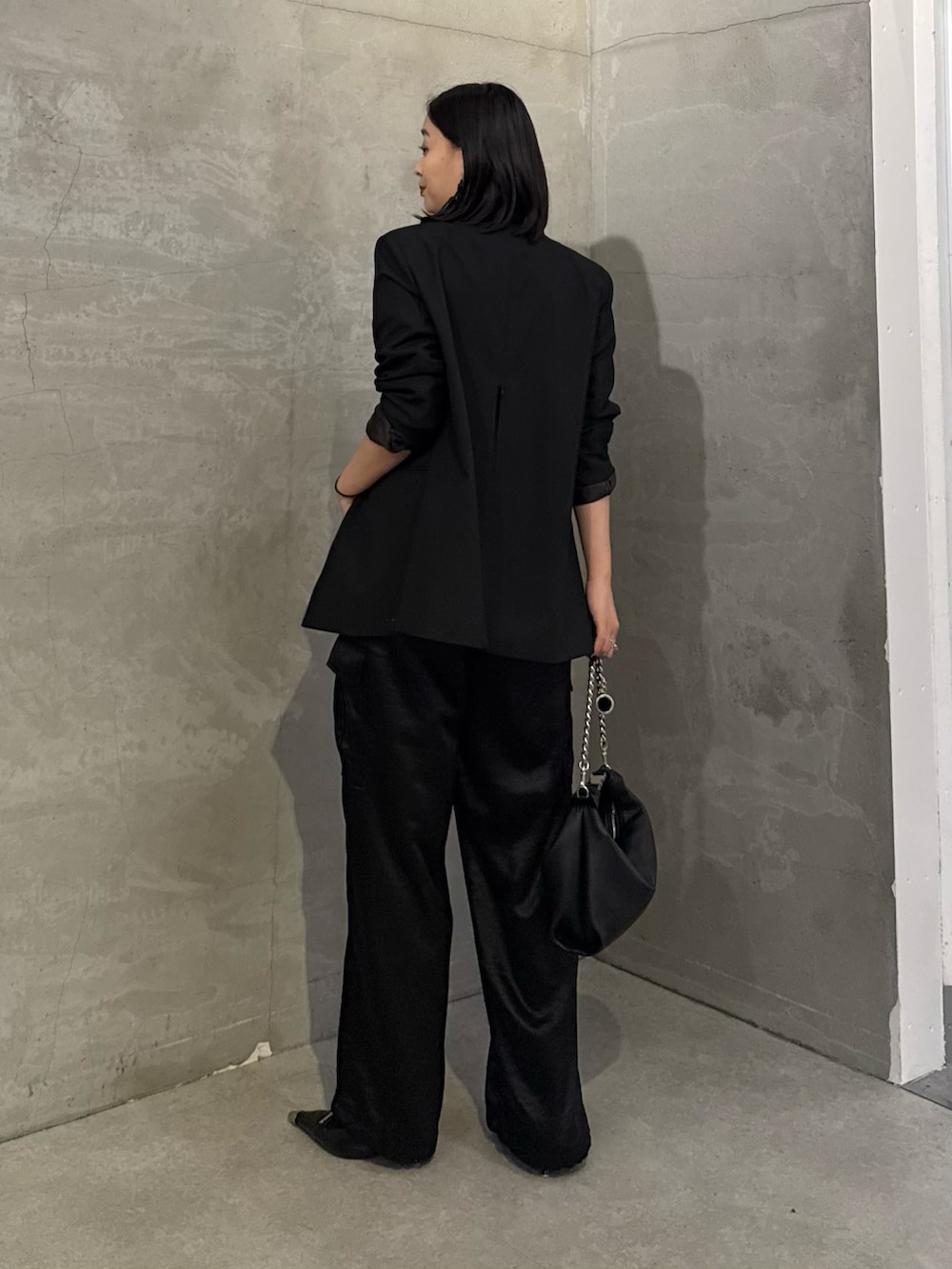 ブラック系のテーラードジャケット、ブラック系のカーゴパンツ、ブラック系のトートバッグを着用したレディースの冬コーディネートの3枚目の写真
