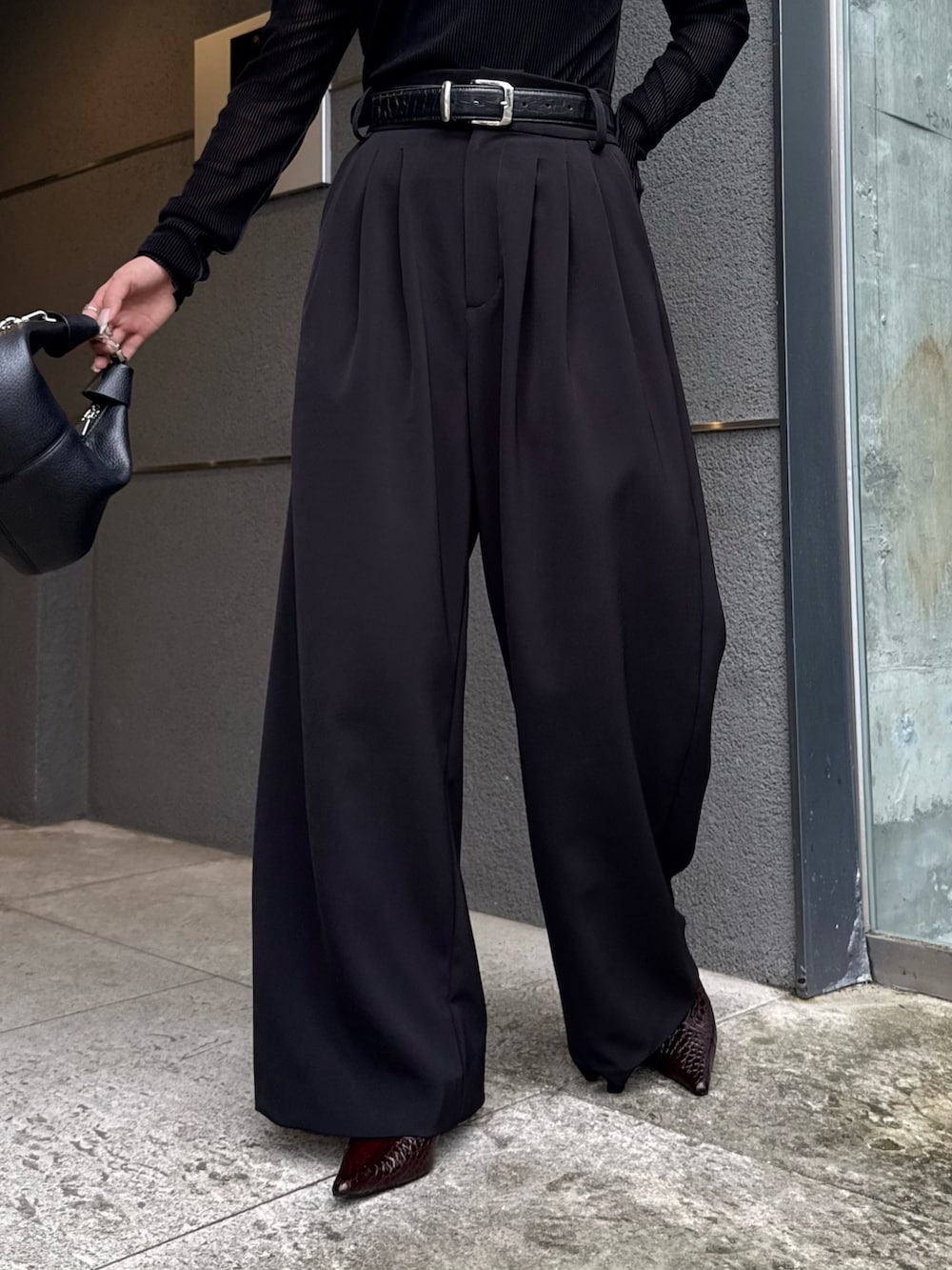 ブラック系のTシャツ/カットソー、ブラック系のスラックス、ブラック系のトートバッグを着用したレディースの秋コーディネートの6枚目の写真