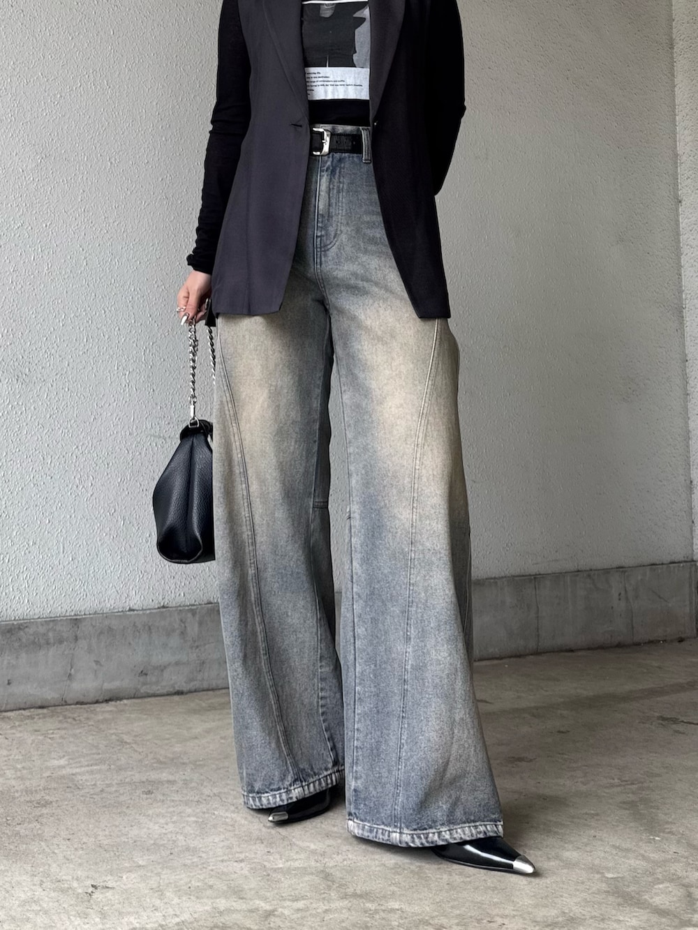 グレー系のベスト、ブラック系のTシャツ/カットソー、ブラック系のデニムパンツを着用したレディースの春コーディネートの6枚目の写真