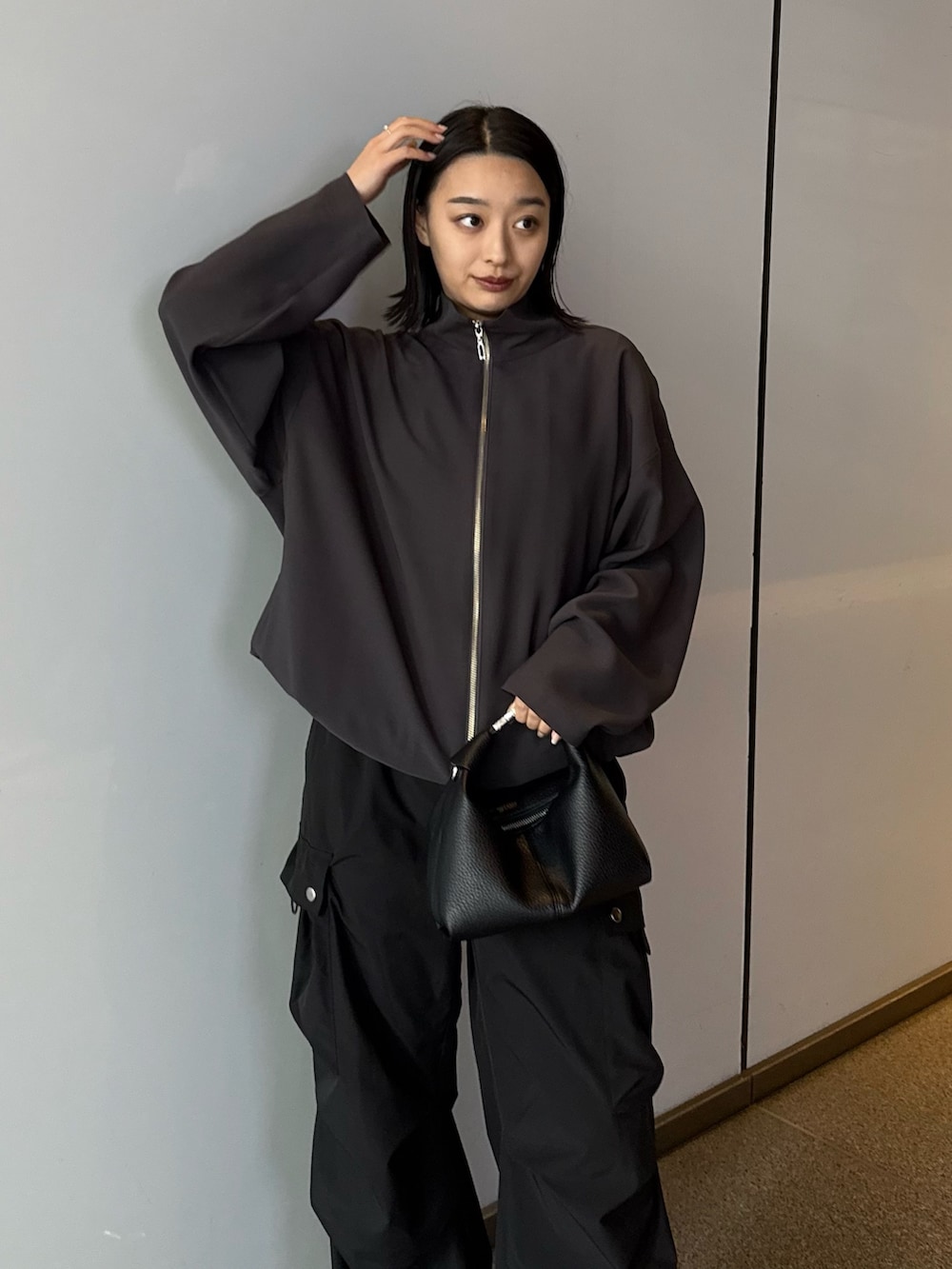 グレー系のシャツ/ブラウス、ブラック系のカーゴパンツ、ブラック系のショルダーバッグを着用したレディースの春コーディネートの2枚目の写真