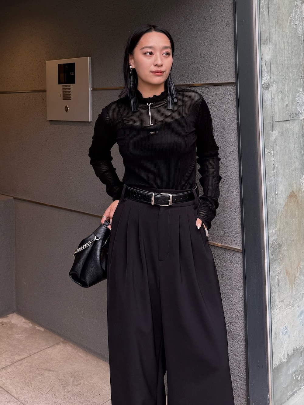 ブラック系のTシャツ/カットソー、ブラック系のスラックス、ブラック系のトートバッグを着用したレディースの秋コーディネートの3枚目の写真