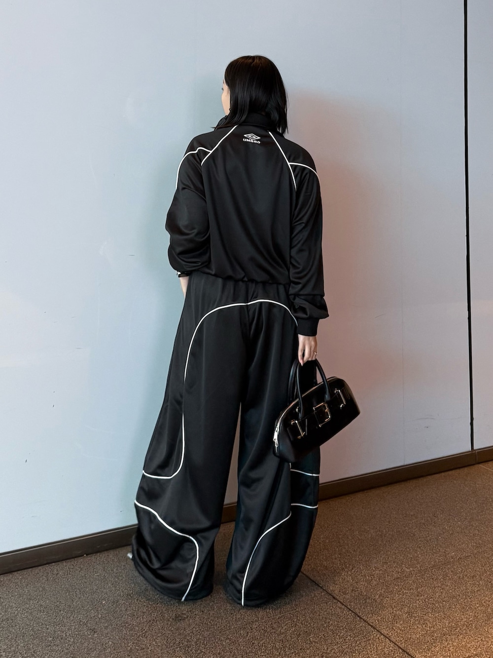 ブラック系のブルゾン、ブラック系のその他パンツ、ブラック系のショルダーバッグを着用したレディースの冬コーディネートの3枚目の写真