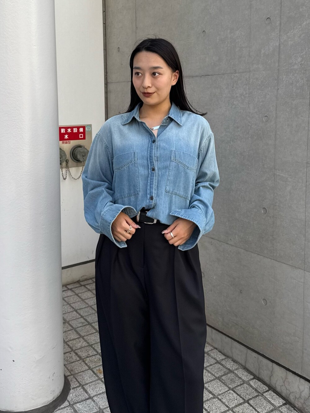 ブルー系のシャツ/ブラウス、ブラック系のスラックス、ブラック系のブーツを着用したレディースの秋コーディネートの3枚目の写真