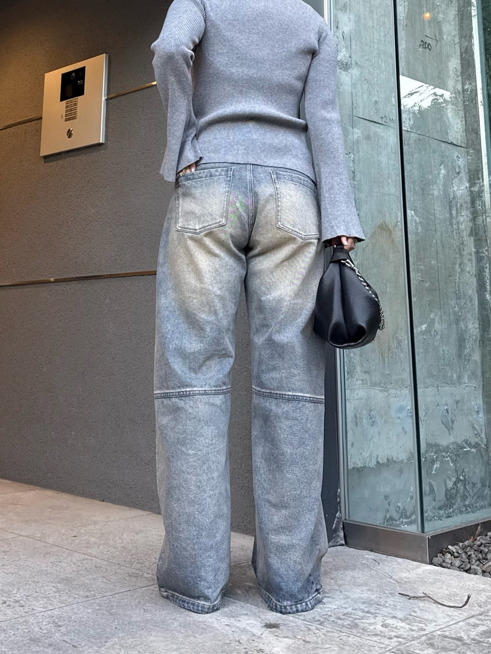 グレー系のニット/セーター、ブルー系のデニムパンツ、ブラック系のトートバッグを着用したレディースの冬コーディネートの7枚目の写真