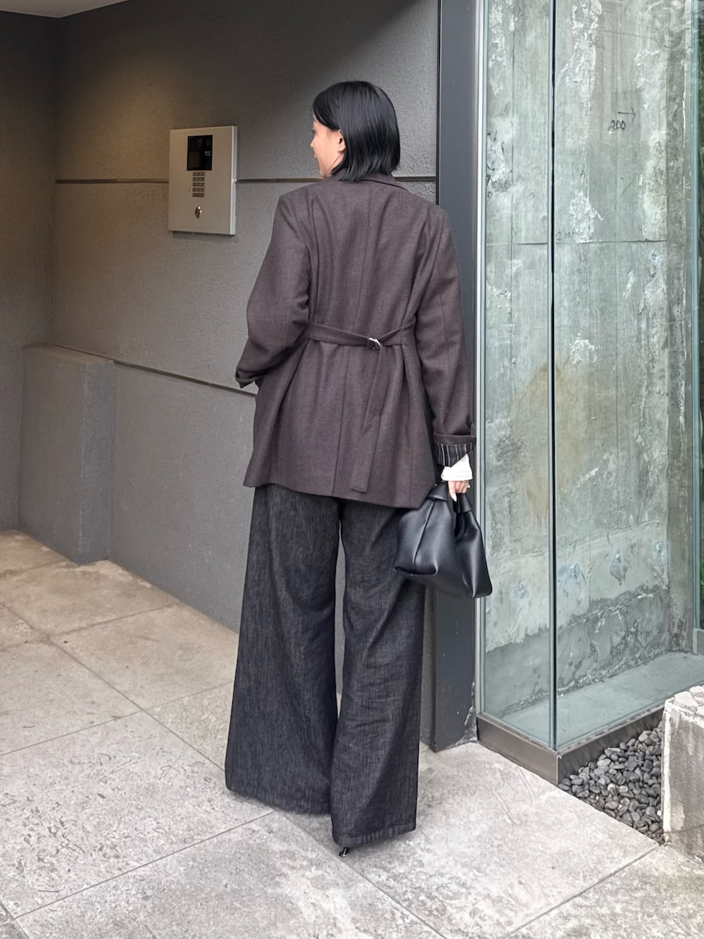 ブラウン系のテーラードジャケット、ホワイト系のTシャツ/カットソー、ブラック系のデニムパンツを着用したレディースの秋コーディネートの2枚目の写真