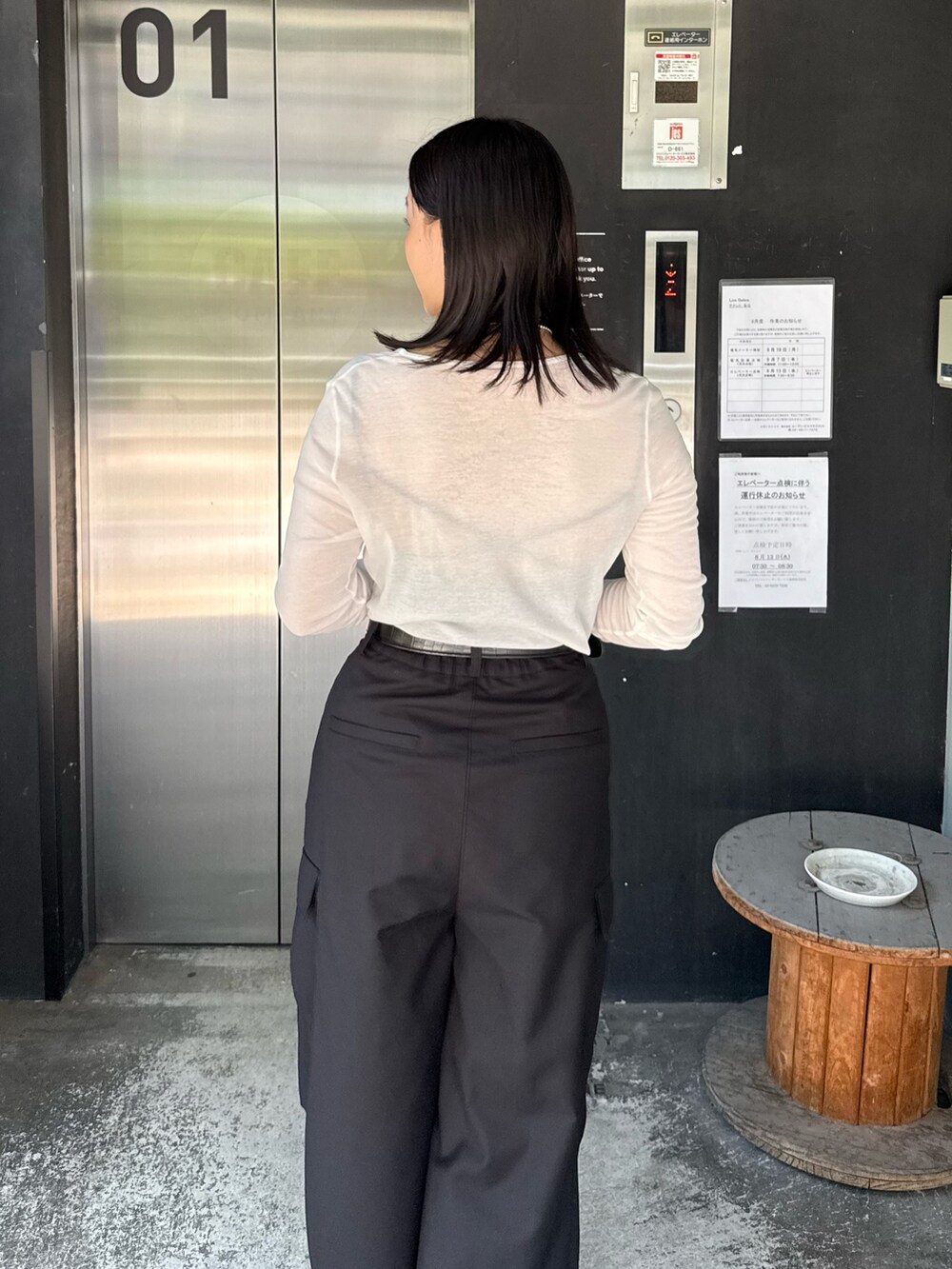 ホワイト系のTシャツ/カットソー、ブラック系のカーゴパンツ、ブラック系のショルダーバッグを着用したレディースの夏コーディネートの4枚目の写真