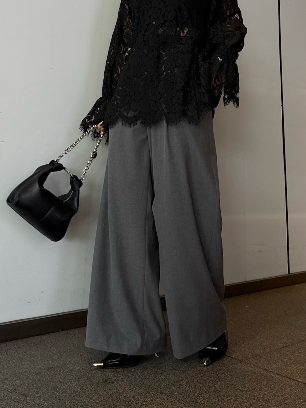 ブラック系のシャツ/ブラウス、グレー系のスラックス、ブラック系のトートバッグを着用したレディースの春コーディネートの6枚目の写真