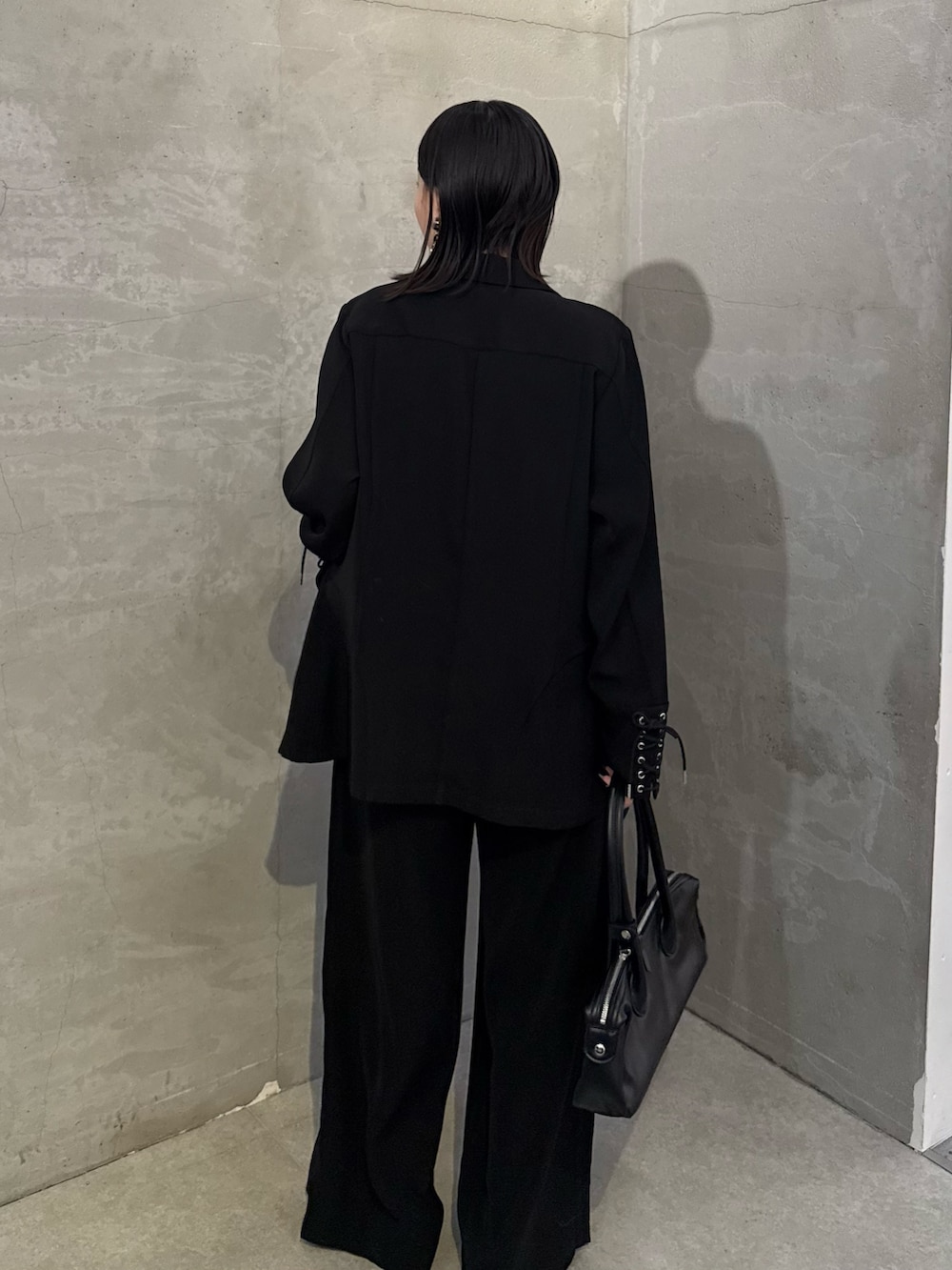 ブラック系のシャツ/ブラウス、ブラック系のスラックス、ブラック系のトートバッグを着用したレディースの冬コーディネートの4枚目の写真