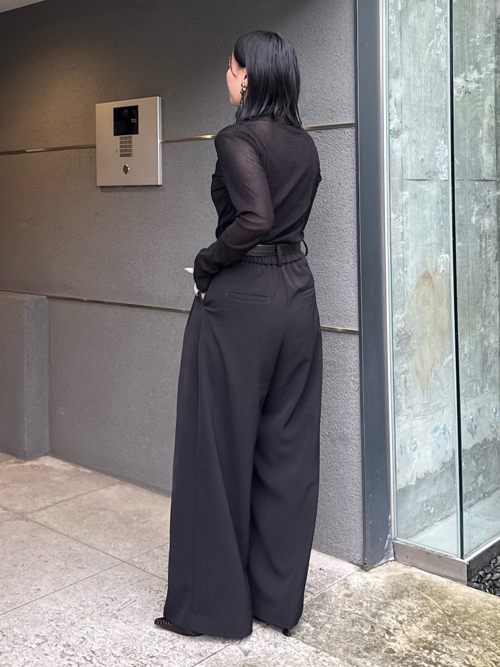 ブラック系のTシャツ/カットソー、ブラック系のスラックス、ブラック系のトートバッグを着用したレディースの秋コーディネートの2枚目の写真