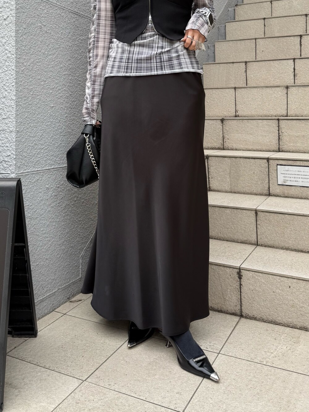ブラック系のTシャツ/カットソー、ブラック系のスカート、ブラック系のトートバッグを着用したレディースの春コーディネートの5枚目の写真