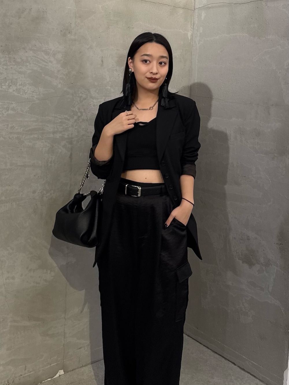 ブラック系のテーラードジャケット、ブラック系のカーゴパンツ、ブラック系のトートバッグを着用したレディースの冬コーディネートの4枚目の写真