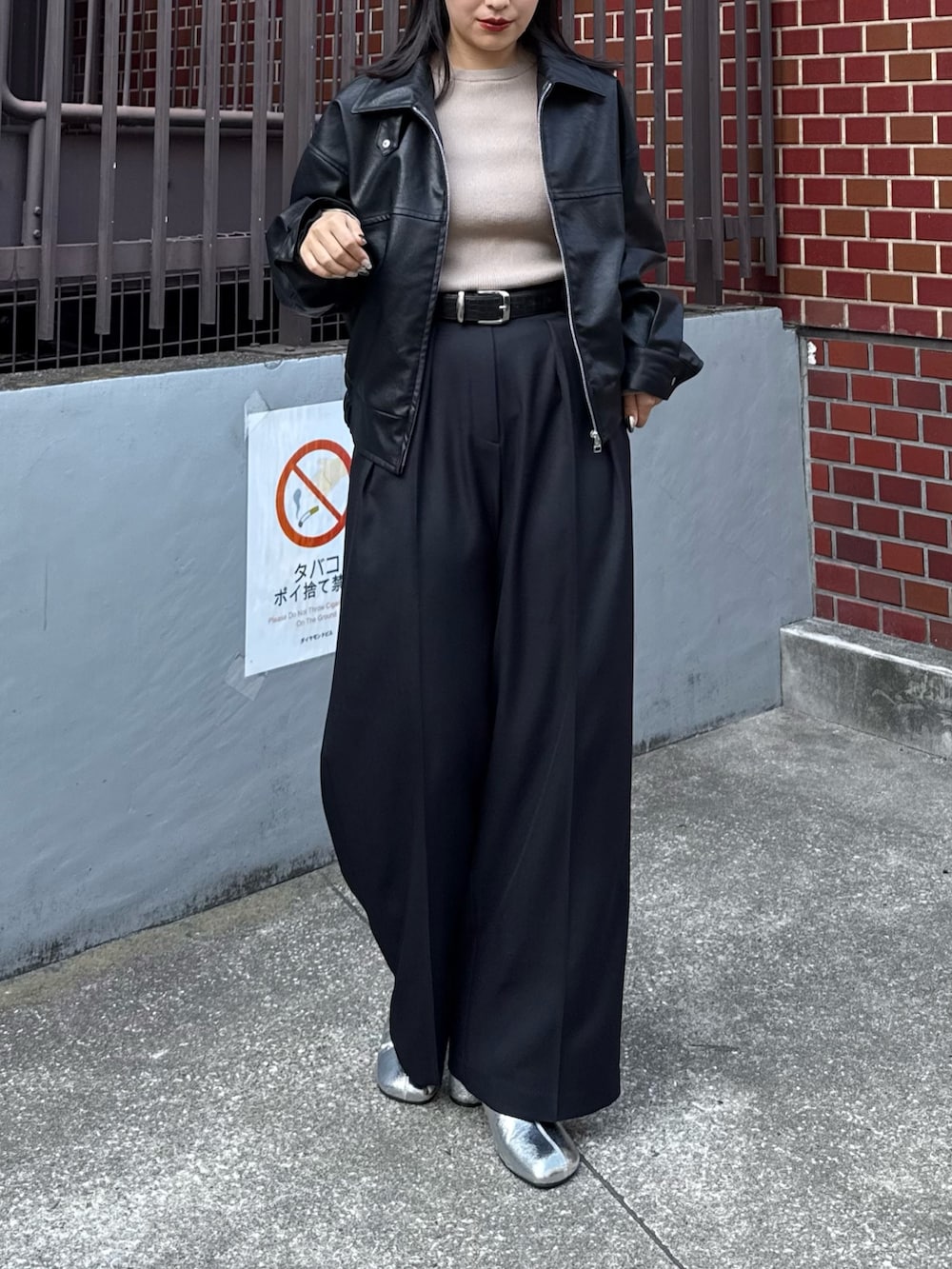 ブラック系のブルゾン、ベージュ系のニット/セーター、ブラック系のスラックスを着用したレディースの秋コーディネートの2枚目の写真