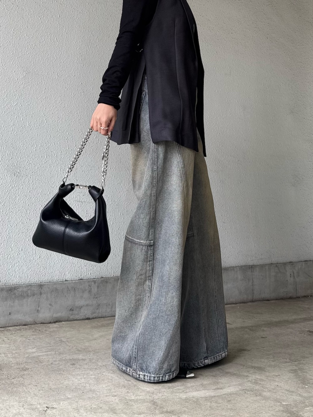 グレー系のベスト、ブラック系のTシャツ/カットソー、ブラック系のデニムパンツを着用したレディースの春コーディネートの7枚目の写真