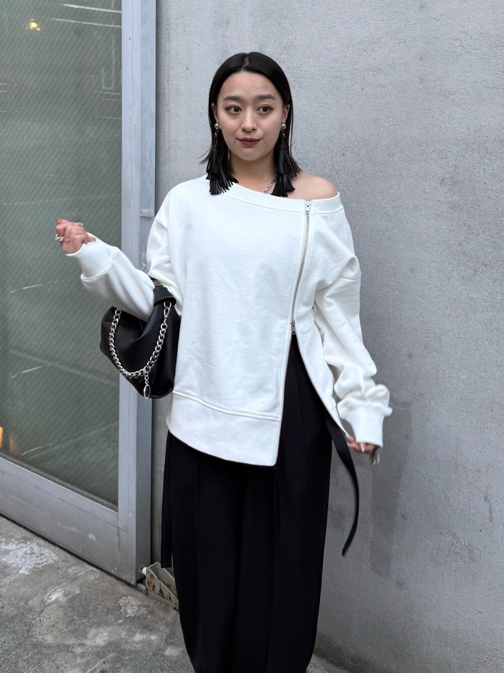 ホワイト系のTシャツ/カットソー、ブラック系のスラックス、ブラック系のトートバッグを着用したレディースの冬コーディネートの4枚目の写真