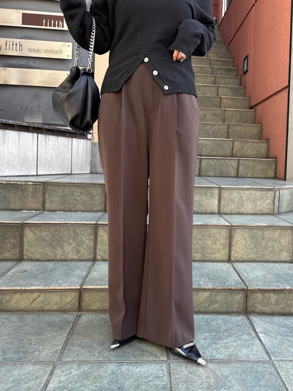 ブラック系のニット/セーター、ブラウン系のスラックス、ブラック系のトートバッグを着用したレディースの冬コーディネートの3枚目の写真