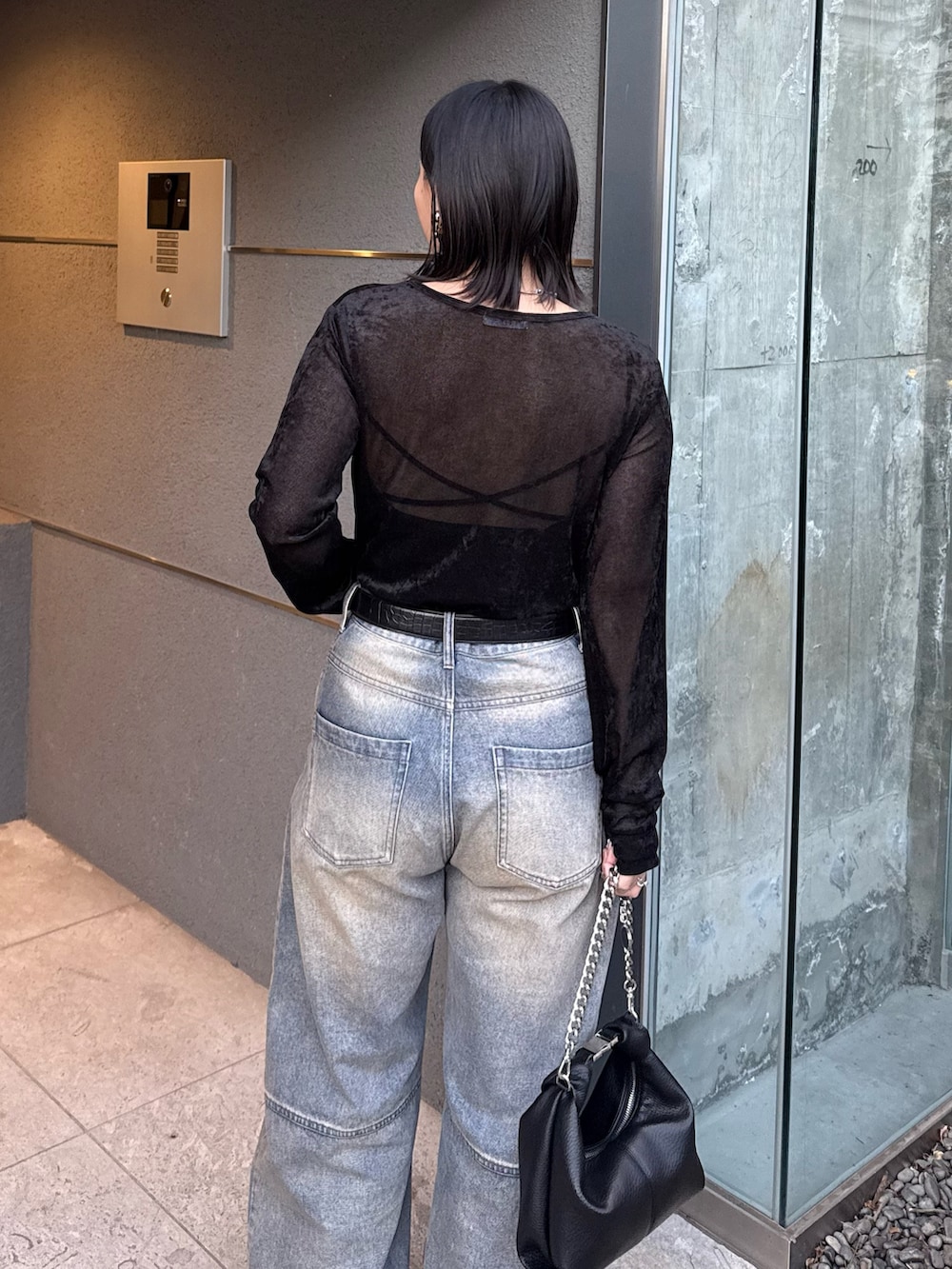 ブラック系のTシャツ/カットソー、ブルー系のデニムパンツ、ブラック系のトートバッグを着用したレディースの冬コーディネートの4枚目の写真