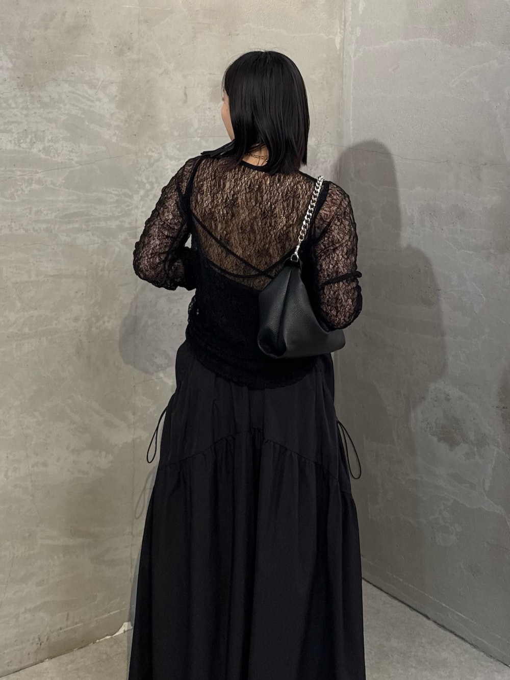 ブラック系のTシャツ/カットソー、ブラック系のスカート、ブラック系のトートバッグを着用したレディースの冬コーディネートの5枚目の写真