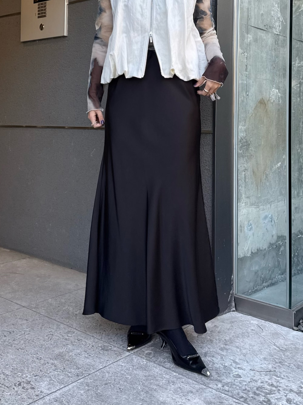 ホワイト系のベスト、グリーン系のTシャツ/カットソー、ブラック系のスカートを着用したレディースの春コーディネートの4枚目の写真