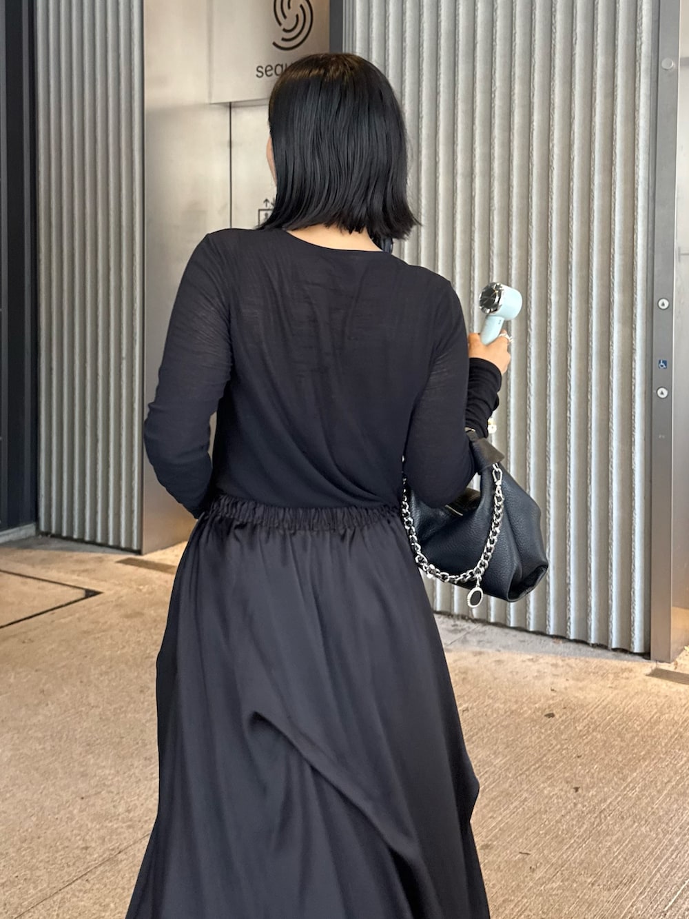 ブラック系のTシャツ/カットソー、ブラック系のスカート、ブラック系のトートバッグを着用したレディースの夏コーディネートの3枚目の写真