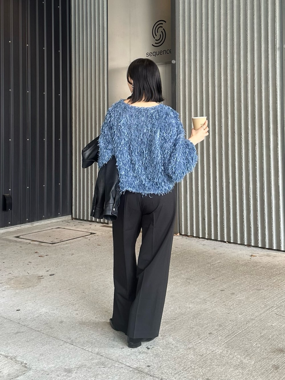 ブルー系のTシャツ/カットソー、ブラック系のスラックス、ブラック系のショルダーバッグを着用したレディースの春コーディネートの3枚目の写真