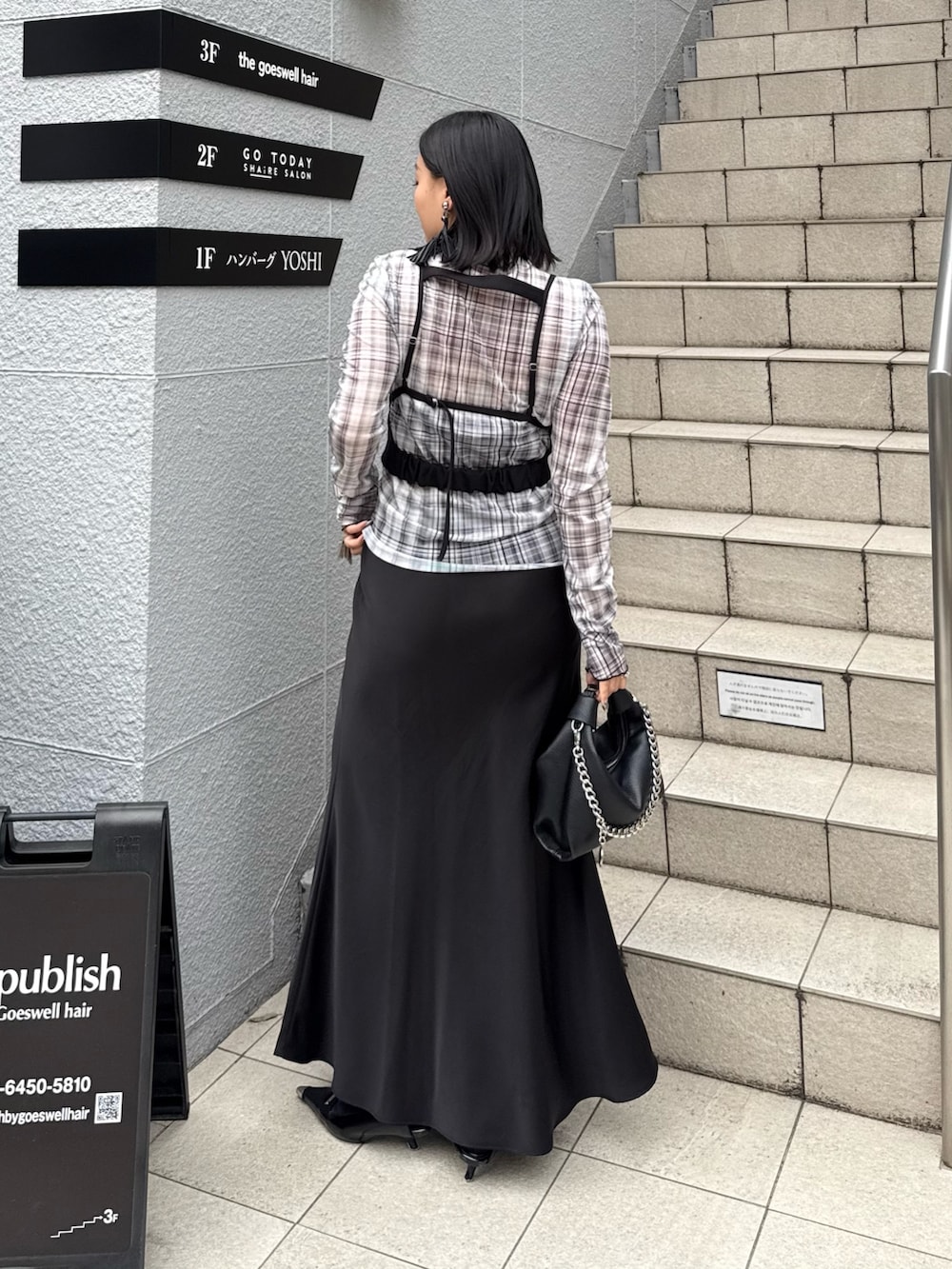 ブラック系のTシャツ/カットソー、ブラック系のスカート、ブラック系のトートバッグを着用したレディースの春コーディネートの2枚目の写真