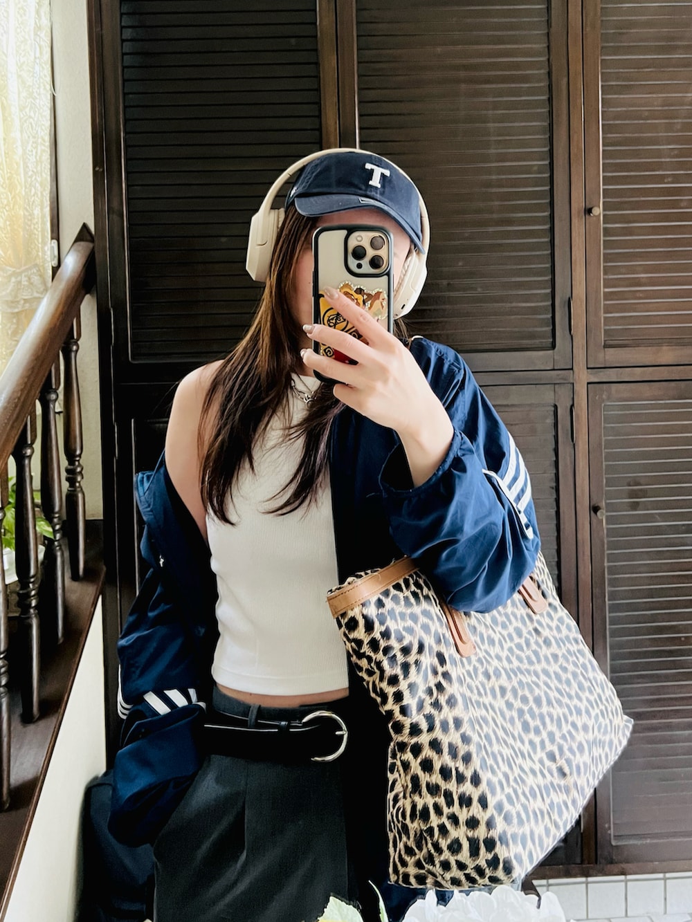 グレー系のスラックス、グレー系のスニーカー、ブルー系のナイロンジャケットを着用したレディースの秋コーディネートの2枚目の写真