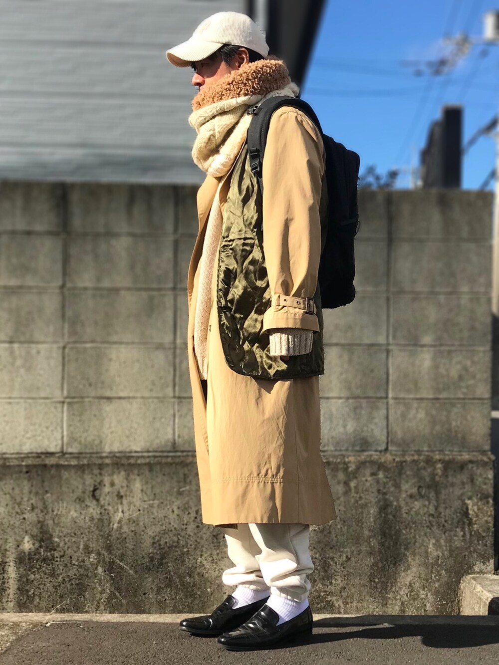 ブラック系のバックパック/リュック、ホワイト系のネックウォーマー/スヌードを着用したメンズの冬コーディネートの2枚目の写真